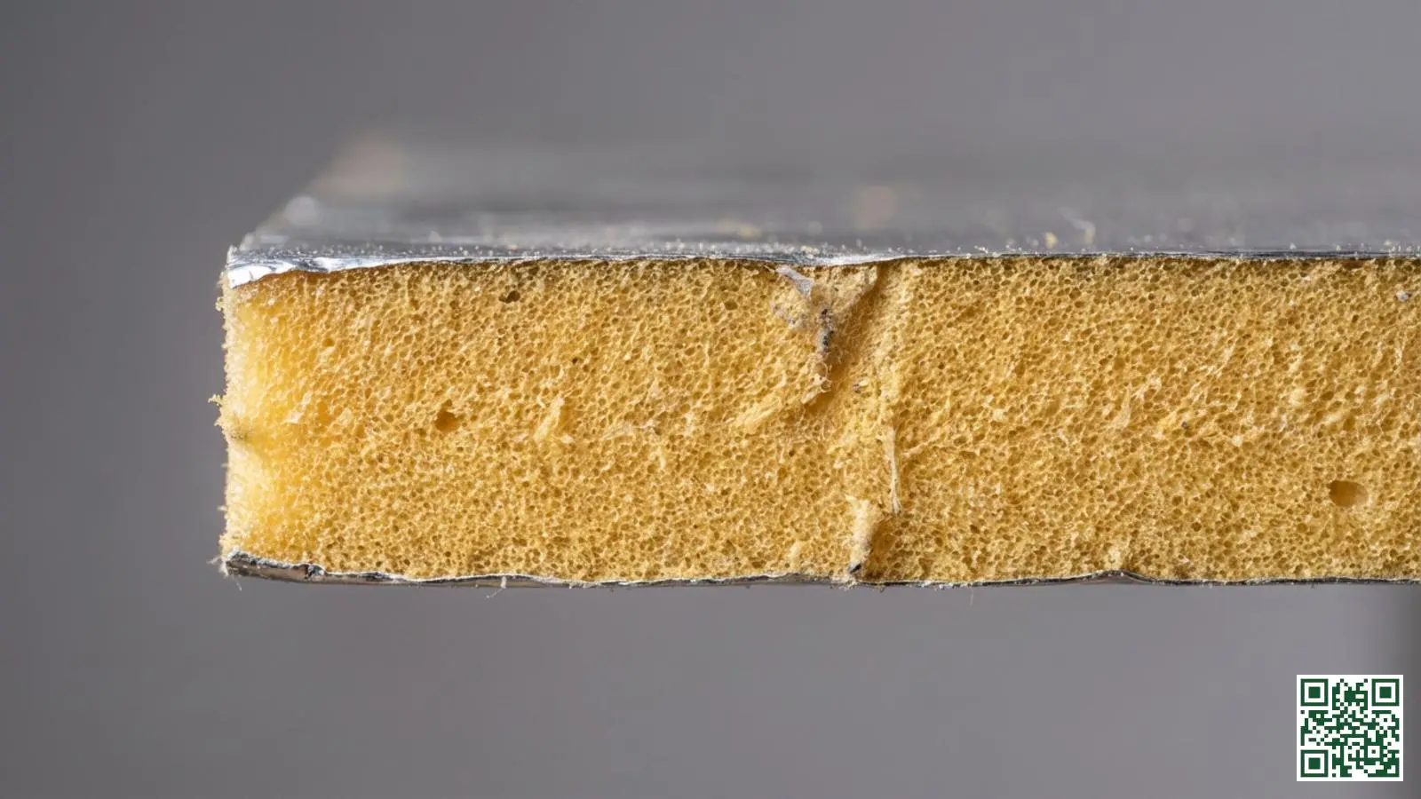 Doorsnede van een PIR isolatieplaat met zichtbare gesloten celstructuur en aluminium kaschering